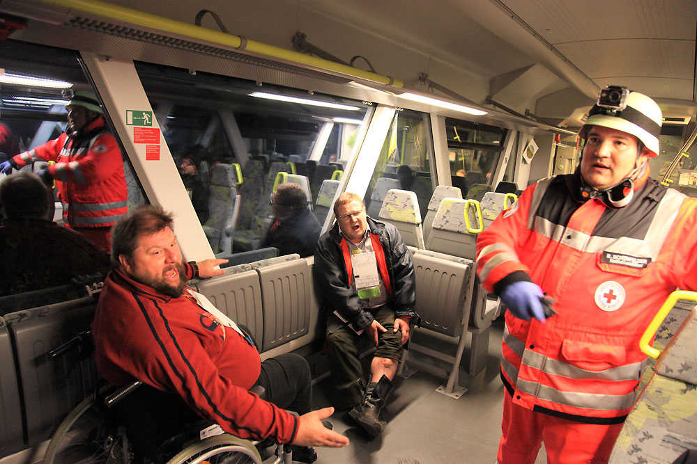 Im Zugabteil wurden rund 25 Personen zum Teil schwer verletzt. Sie mussten nach einer ersten Sichtung in Zusammenarbeit von BRK und Feuerwehr gerettet und aus dem Zug transportiert werden, unter ihnen auch ein Rollstuhlfahrer. (Foto: Michael Will / BRK)