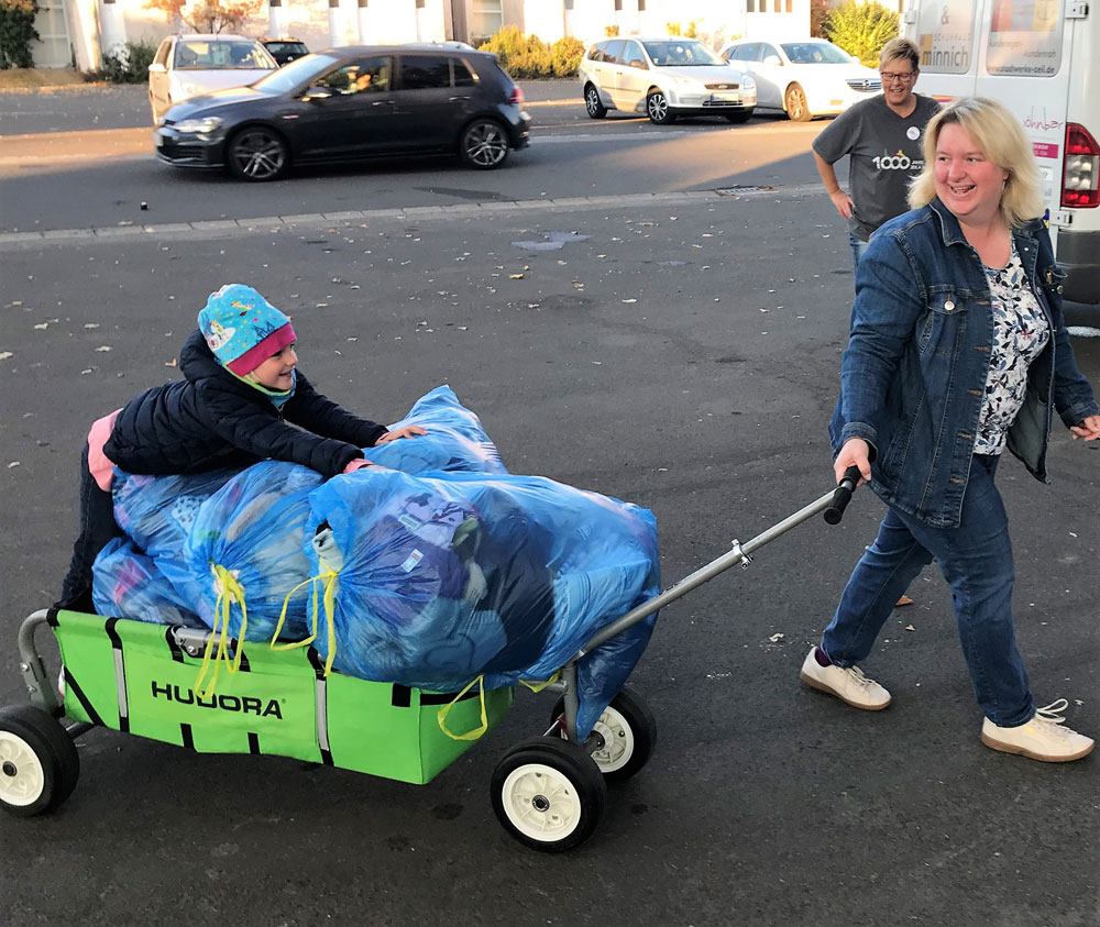 Als Transportmittel für die Altkleidersäcke dient am Samstag nahezu jedes Gefährt: Tanja Hamm liefert zusammen mit Tochter Lena Säcke mit einem Handwagen an. (Foto: Michael Will / BRK)