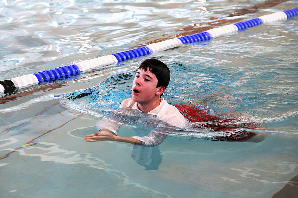 Manuel Lübke demonstriert den Zuschauern das Schwimmen mit Kleidung. (Foto: Michael Will / BRK)