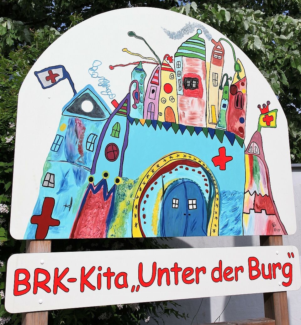 Eine freundliche gestaltete Begrüßungstafel empfängt die Besucher im Kindergarten „Unter der Burg“. (Foto: Michael Will / BRK.)