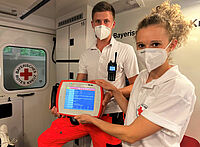Lukas Krapf (li., Notfallsanitäter-Auszubildender) und Luisa Dukorn (Rettungssanitäterin) zeigen das NIDA-Pad. (Foto: Michael Will / BRK)