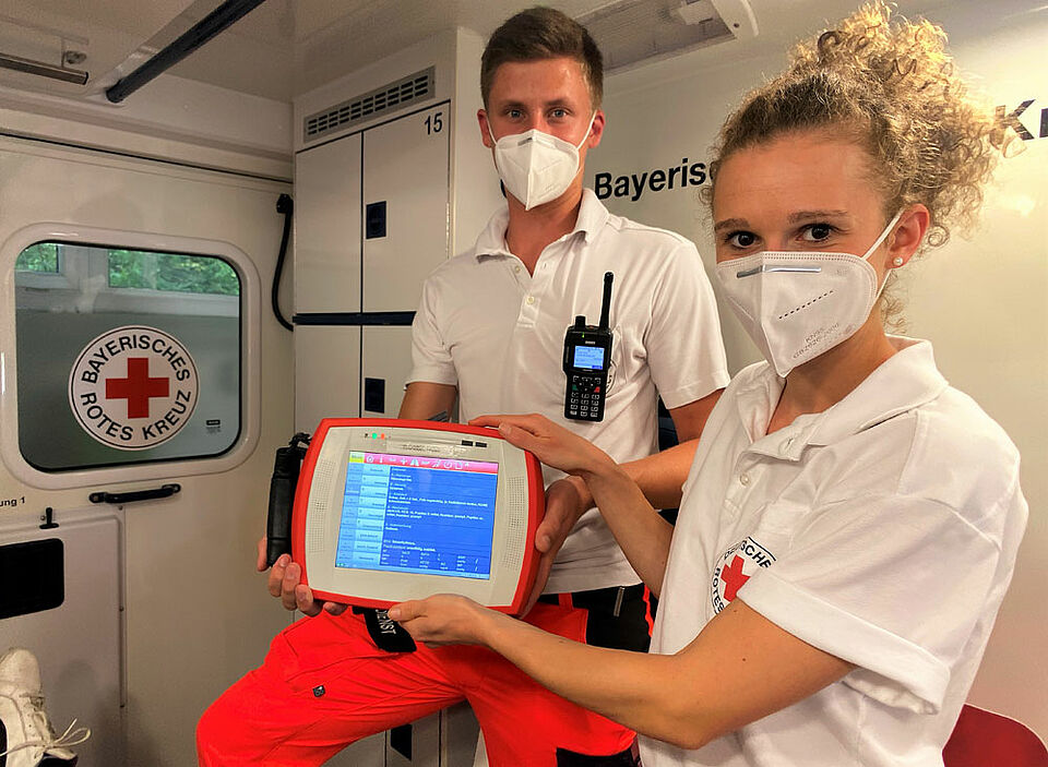 Lukas Krapf (li., Notfallsanitäter-Auszubildender) und Luisa Dukorn (Rettungssanitäterin) zeigen das NIDA-Pad. (Foto: Michael Will / BRK)