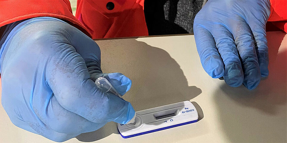 Der in einer Trägerflüssigkeit gelöste Abstrich wird zur Auswertung auf einen Teststreifen getropft. Wenig später kann das Ergebnis abgelesen werden. (Foto: Michael Will / BRK)