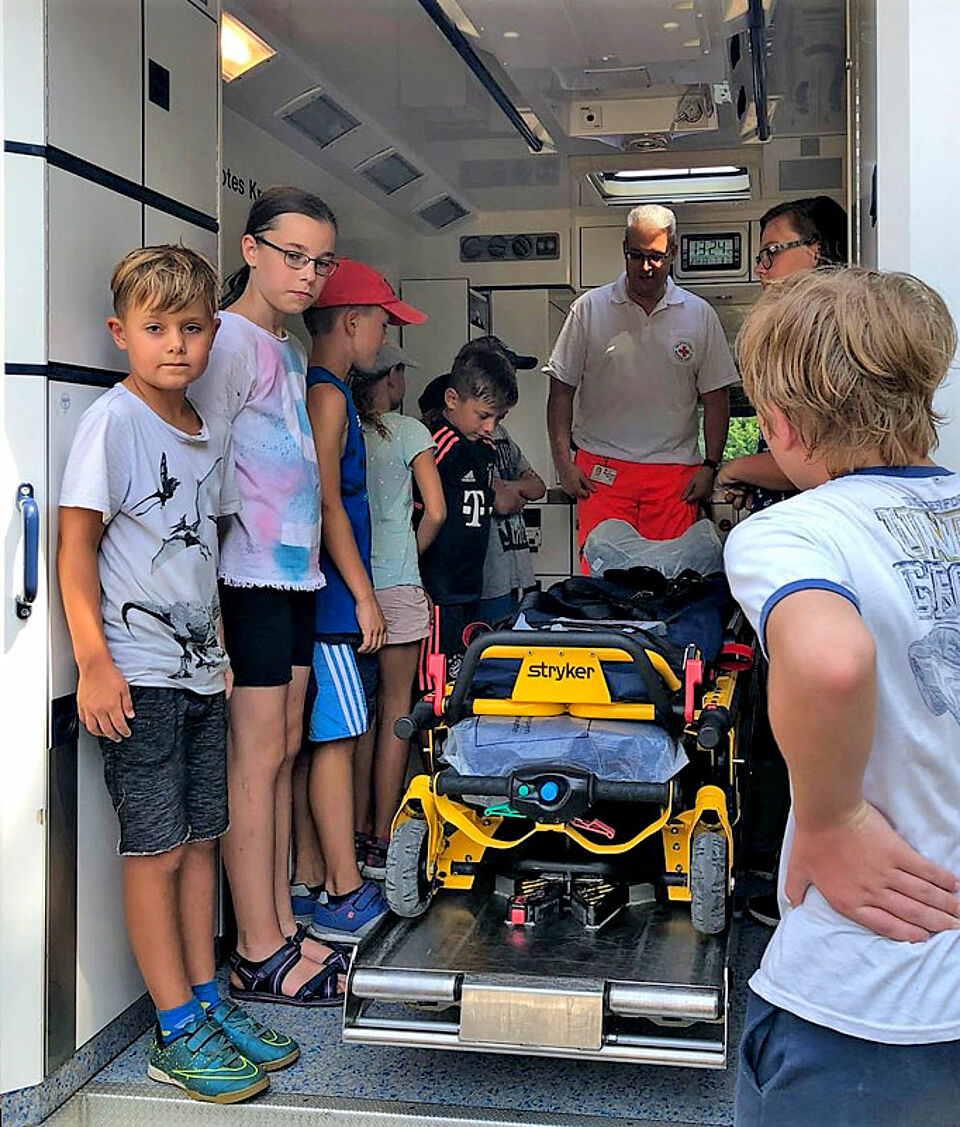 Die Kinder durften selbst einmal auf der fahrbaren Trage Platz nehmen und sich von anderen Kindern ein Stück weit fahren lassen. (Foto: Michael Will / BRK)