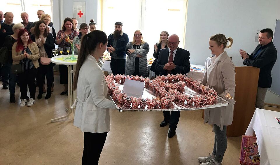 Das neue Lebensjahrzehnt versüßt: 60 Muffins hatten die Mitarbeiterinnen des Mehrgenerationenhauses gebacken und überreichten diese an BRK-Kreisgeschäftsführer Dieter Greger (Mitte), der sich über diese Überraschung sichtlich freute. (Foto: Michael Will / BRK)