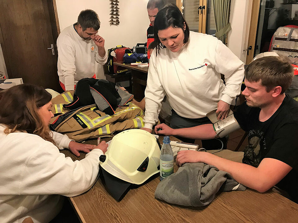 Nach ihrem anstrengenden Einsatz mit schwerem Atemschutz wurden die Feuerwehrleute von der SEG Behandlung des BRK medizinisch untersucht. (Foto: Michael Will / BRK)