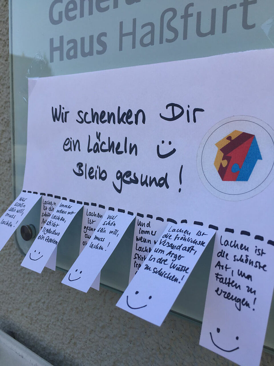An der Hausfassade des Mehrgenerationenhauses hängen Abreißzettel mit schönen Sprüchen zum Mitnehmen. (Foto: Simone Hümmer / BRK )